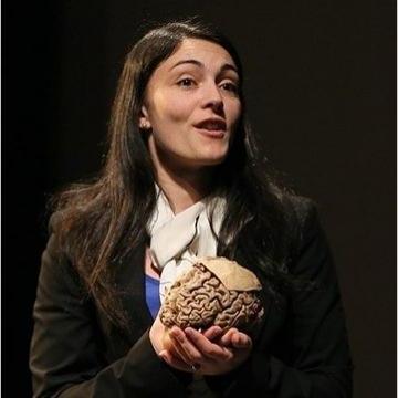 Professor Victoria Heimer-McGinn speaking and holding a human brain.