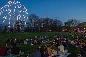 students sitting outside watching fireworks